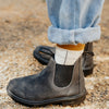 Blundstone Chelsea Boot rustikales grau, Tragefoto von der Seite, wasserdicht mit robuster Sohle, seitliche Gummis Ton in Ton. schwarze Sohle