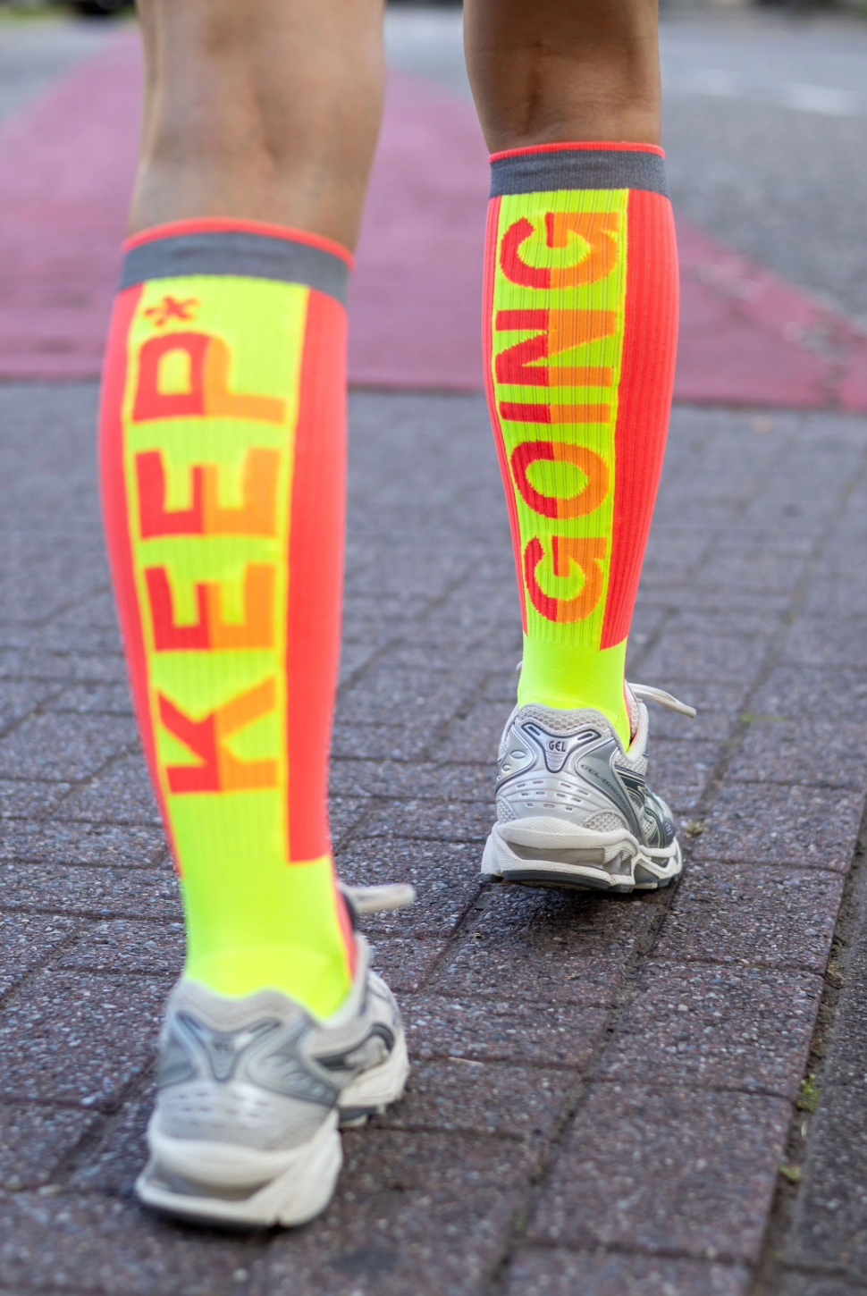 Coral Go Fluo Blaze reflective high-running socks displayed on a white background, highlighting their vibrant color and design.
