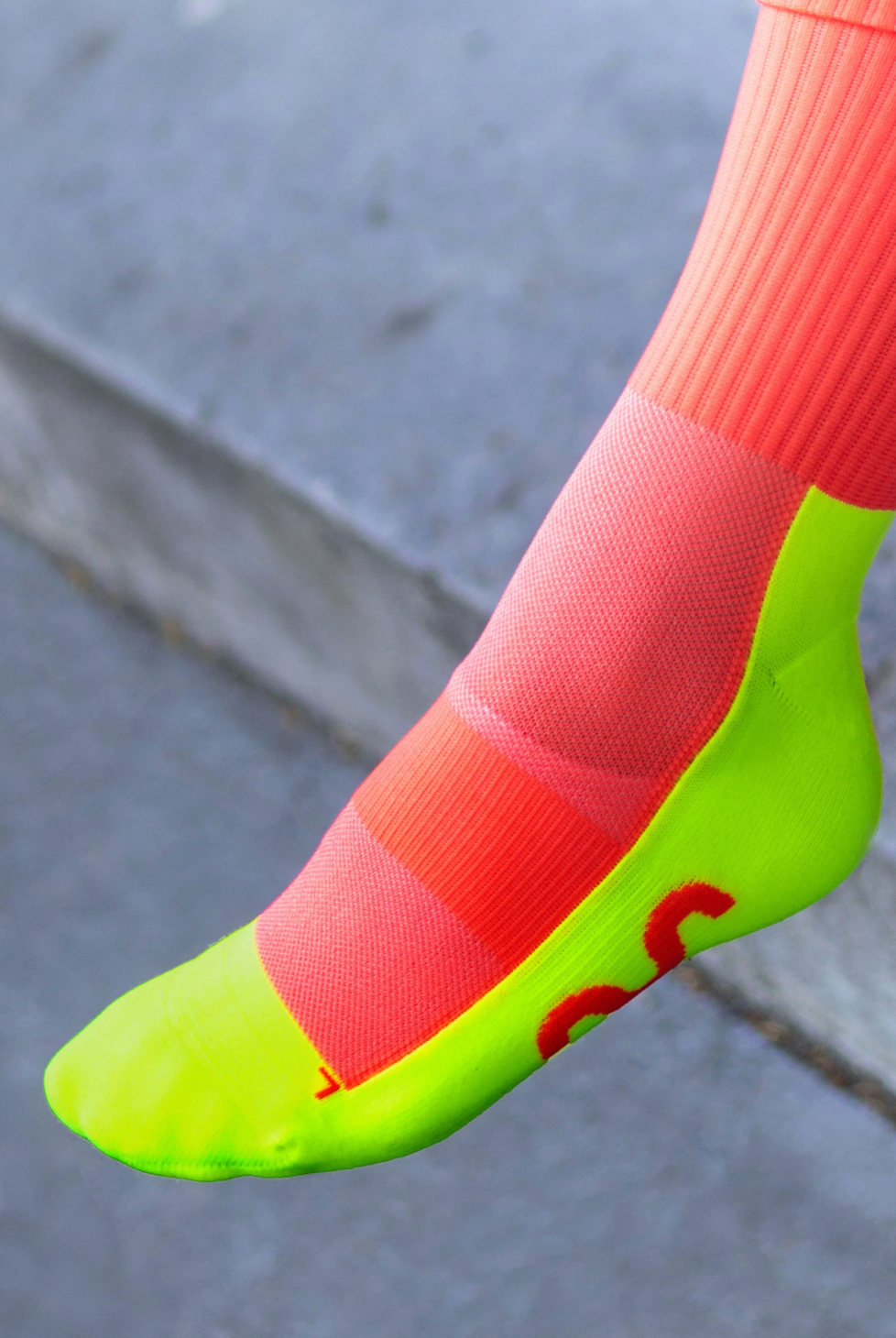 Go Fluo coral high-running socks with reflective details, perfect for visibility during outdoor activities.
