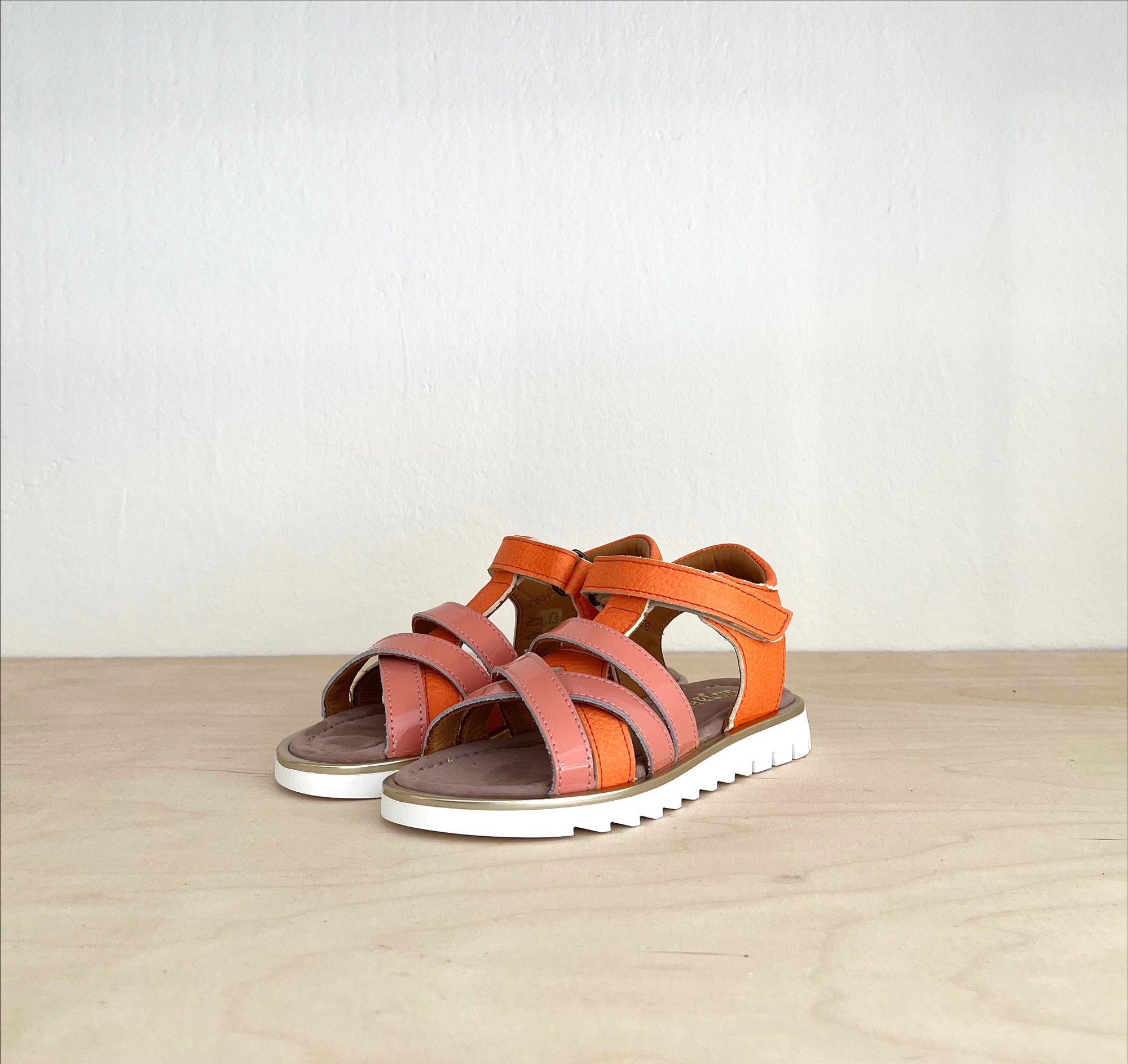 Süße Sandalen für Kinder in Orange. Ansicht von schräg vorne.