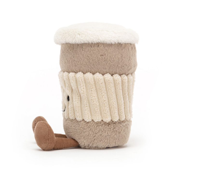 Der beliebte Jellycat CoffeToGo Becher von jellycat sieht flauschig aus, hat zwei Beinchen mit Füßen. Ist insgesamt beigebraun, mit einer "geriffelten" cremefarbenen Manschette mit Gesicht. Der flauschige Deckel ist weiß. Seitenansicht.