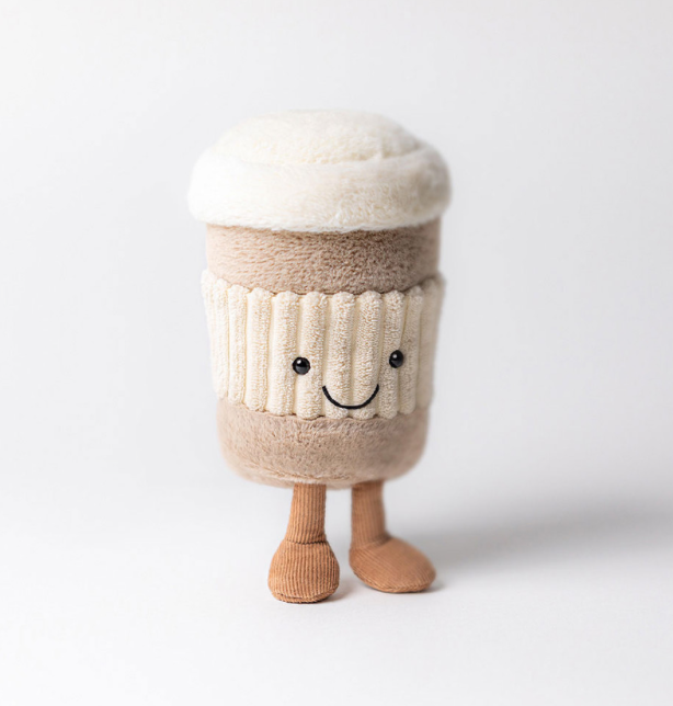 Der beliebte Jellycat CoffeToGo Becher von jellycat sieht flauschig aus, hat zwei Beinchen mit Füßen. Ist insgesamt beigebraun, mit einer "geriffelten" cremefarbenen Manschette mit Gesicht. Der flauschige Deckel ist weiß.