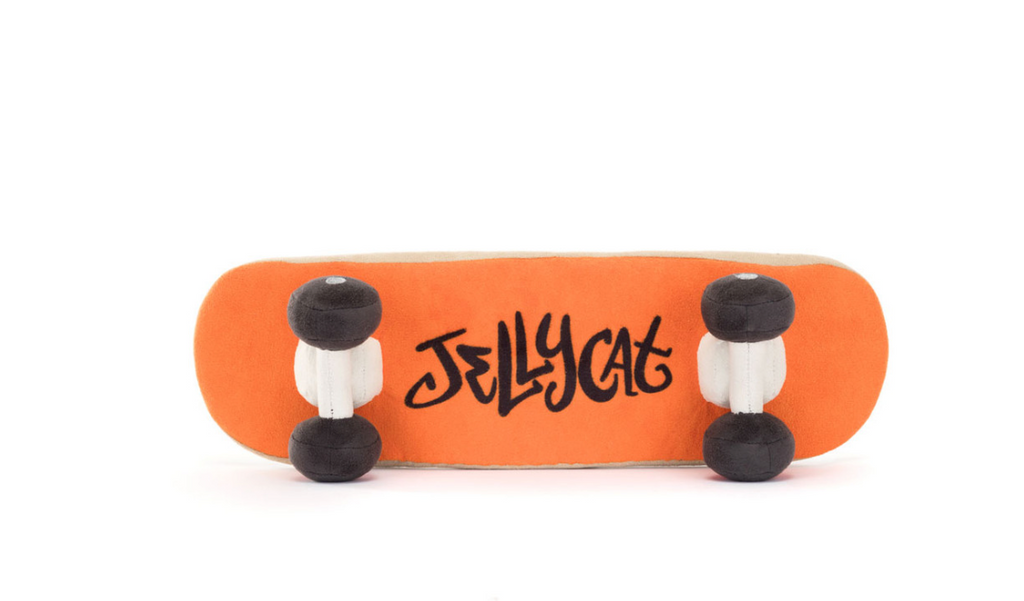 Die Rückseite des Jellycat Amuseables Sports Skateboarding Kuscheltiers ist Orange mit einem gestickten schwarzen Jellycat-Schriftzug im Graffiti-Style. Rechts und links von dem Graffitisind die Plüsch-Rollen angebracht