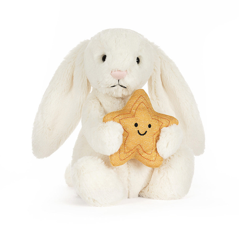 kuscheliger Jellycat Hase in weiß mit goldenem Sternenkuscheltier im Arm, Frontansicht