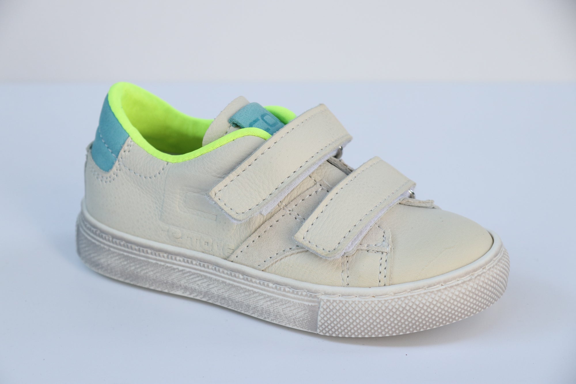 Coole Cole Bounce Offwhite Neongelbe Kinderhalbschuhe mit Klettverschluss. Weißer Schuh mit Neongelbem Innenfutter und blauen Details