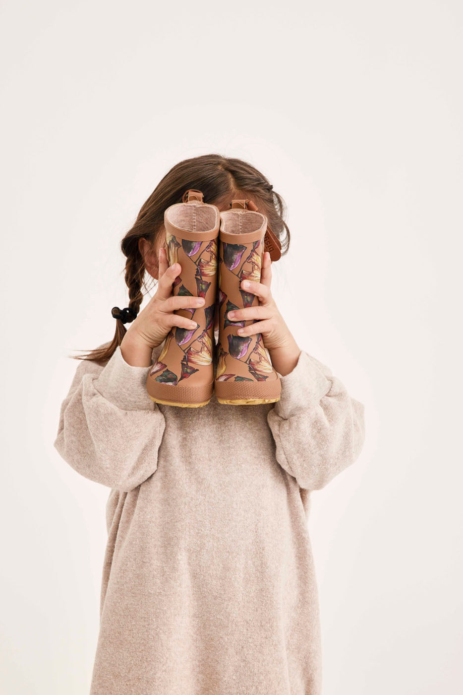 Wunderschöne Bisgaard Kindergummistiefel Flowers. Braune Gummistiefel mit Blumenmuster, Gehalten von Mädchen