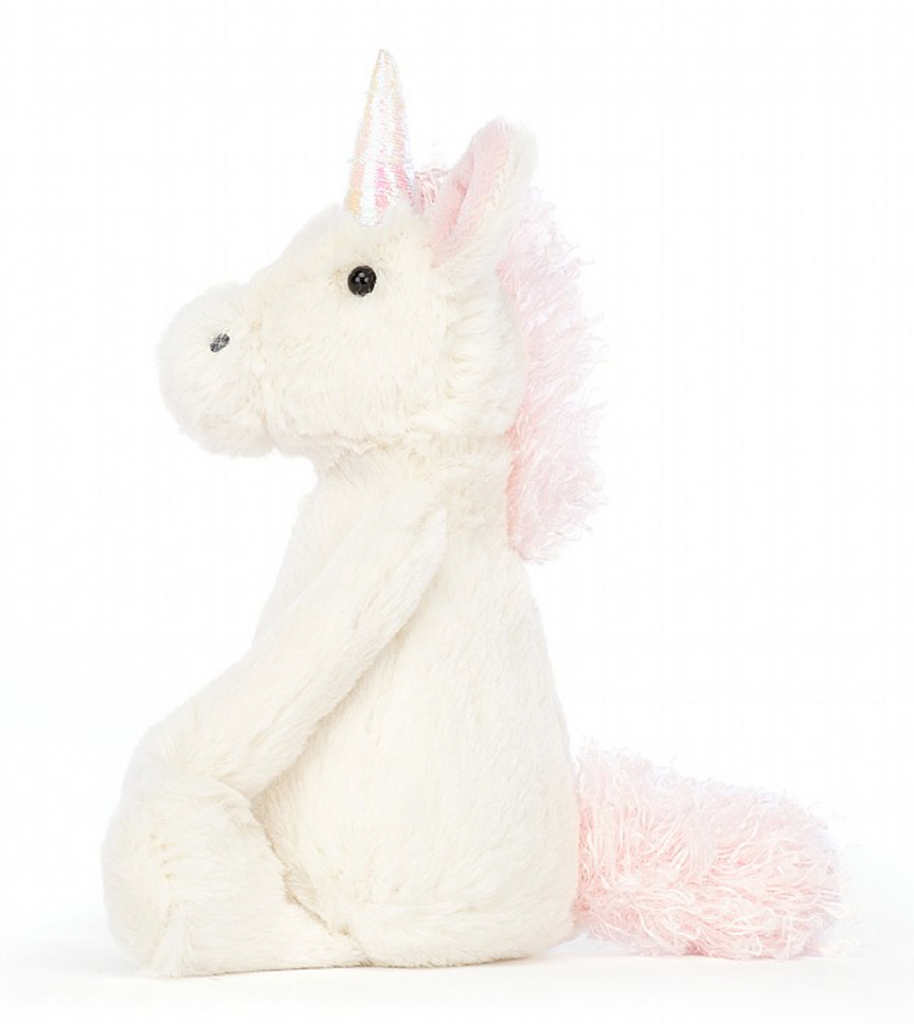 Verschmustes Bashful Unicorn Kuscheltier von Jellycat. Plüschiges Einhorn mit weißem Fell und rosaner Mähne und Schweif. Seitliche Ansicht