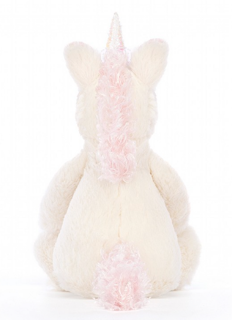 Verschmustes Bashful Unicorn Kuscheltier von Jellycat. Plüschiges Einhorn mit weißem Fell und rosaner Mähne und Schweif. Ansicht von hinten