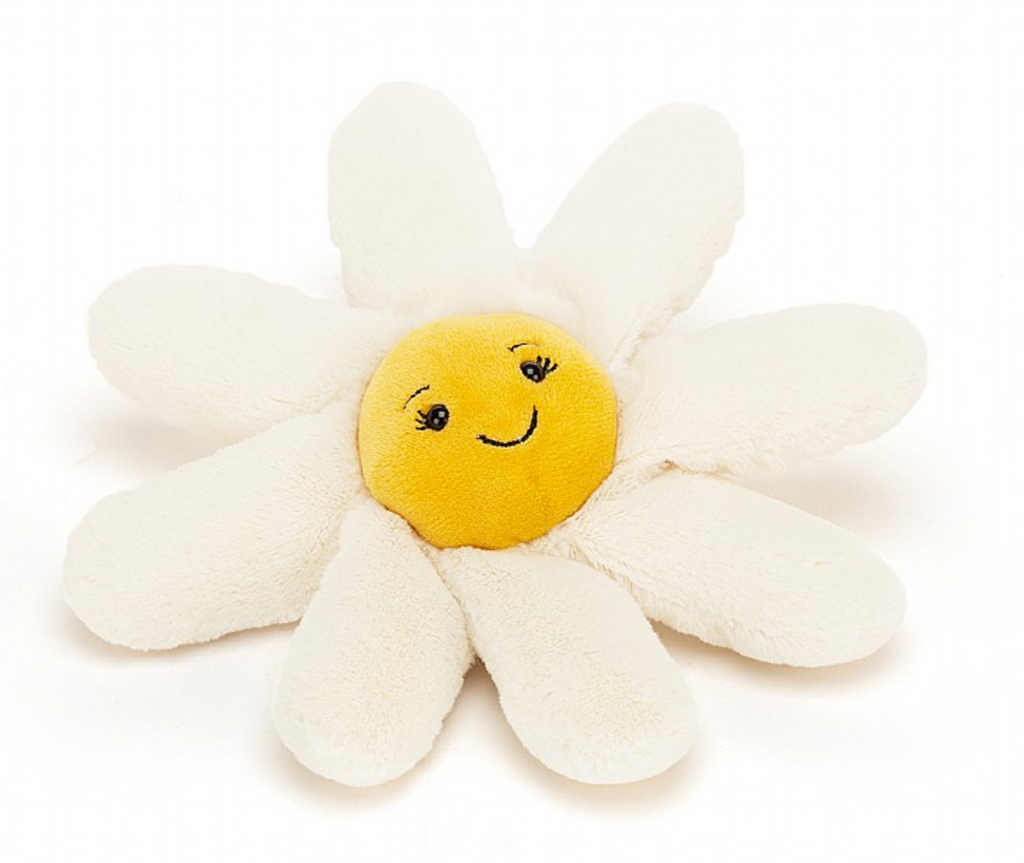 Flauschiges Jellycat Blumen Kuscheltier Fleury Daisy in klein. Süßes Gänseblümchen mit weißen Blättern und gelbem Kopf mit lächelndem Gesicht. Ansicht von vorne, liegend 